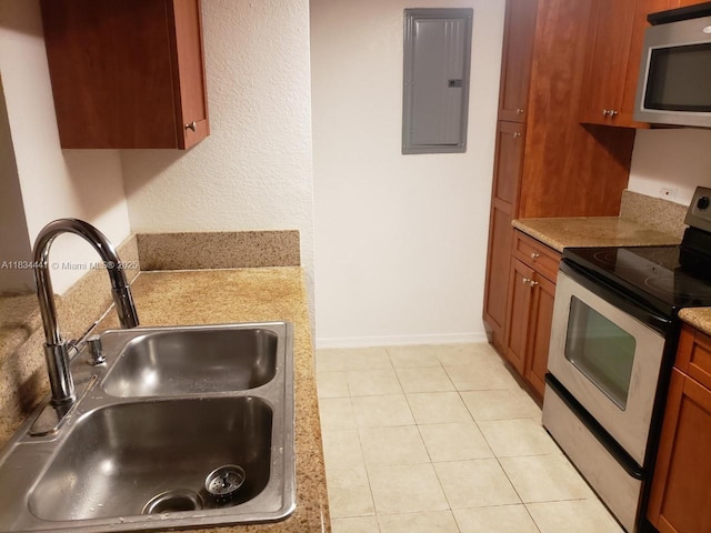 36 NW 6th Ave Unit 906, Miami, FL 33128 - kitchen featuring appliances with stainless steel finishes, electric panel, light tile patterned floors, brown cabinetry, and light countertops