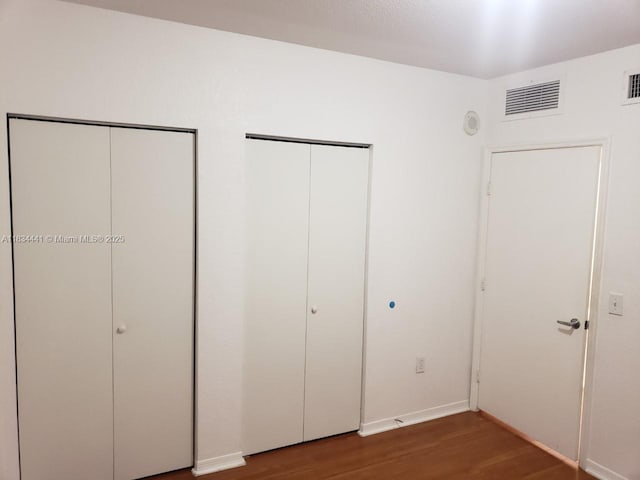 36 NW 6th Ave Unit 906, Miami, FL 33128 - unfurnished bedroom with multiple closets and wood finished floors