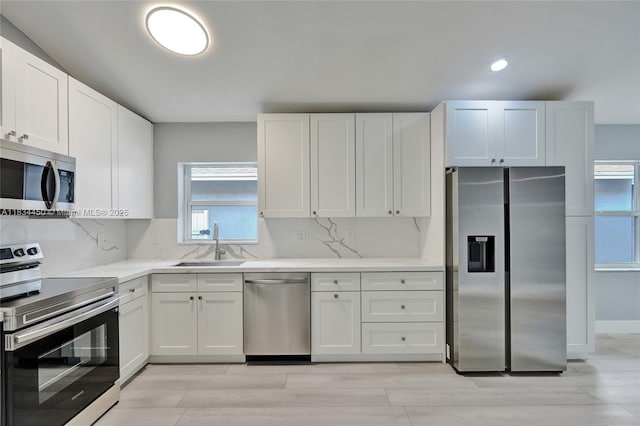2349 NW 34th Ave, Coconut Creek, FL 33066 - kitchen featuring appliances with stainless steel finishes, white cabinetry, backsplash, and recessed lighting