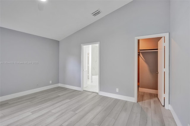 2349 NW 34th Ave, Coconut Creek, FL 33066 - unfurnished bedroom featuring lofted ceiling, a spacious closet, light wood finished floors, a closet, and connected bathroom
