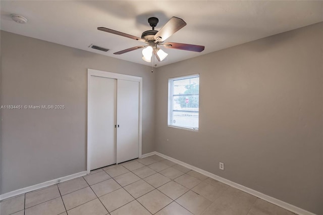 4423 Lake Ave, West Palm Beach, FL 33405 - unfurnished bedroom with light tile patterned floors, a closet, and a ceiling fan
