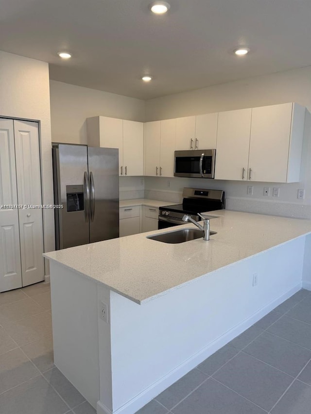 2893 SE 25th Rd Unit 2893, Homestead, FL 33035 - kitchen with stainless steel appliances, a peninsula, light stone counters, light tile patterned flooring, and recessed lighting