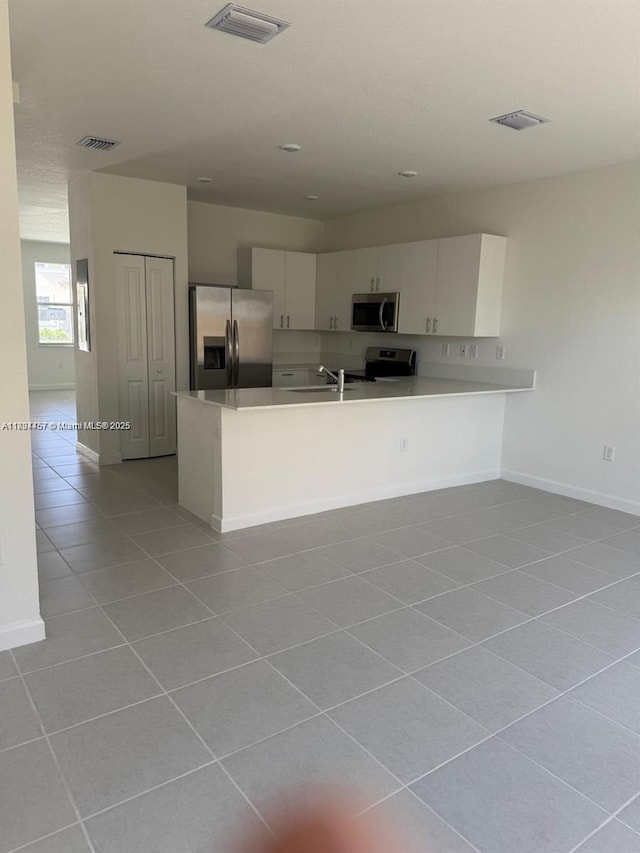 2893 SE 25th Rd Unit 2893, Homestead, FL 33035 - kitchen with stainless steel appliances, light tile patterned flooring, light countertops, a peninsula, and white cabinetry