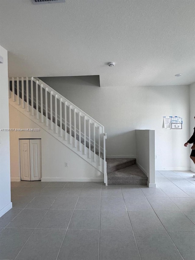 2893 SE 25th Rd Unit 2893, Homestead, FL 33035 - stairs with tile patterned flooring and a textured ceiling