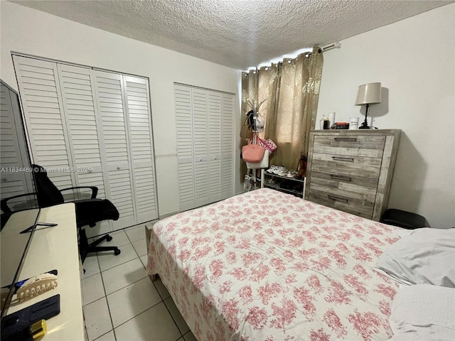 10090 NW 80th Ct Unit 1401, Hialeah Gardens, FL 33016 - bedroom with two closets, a textured ceiling, and tile patterned floors