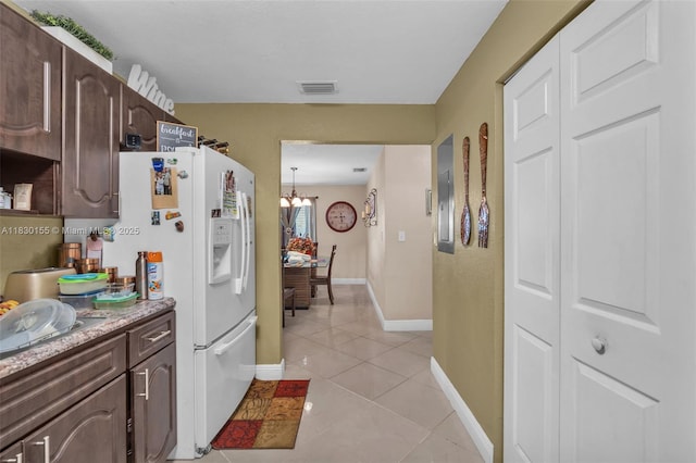 2175 NW 50th St, Miami, FL 33142 - kitchen with white refrigerator with ice dispenser, dark brown cabinetry, a chandelier, and light tile patterned floors