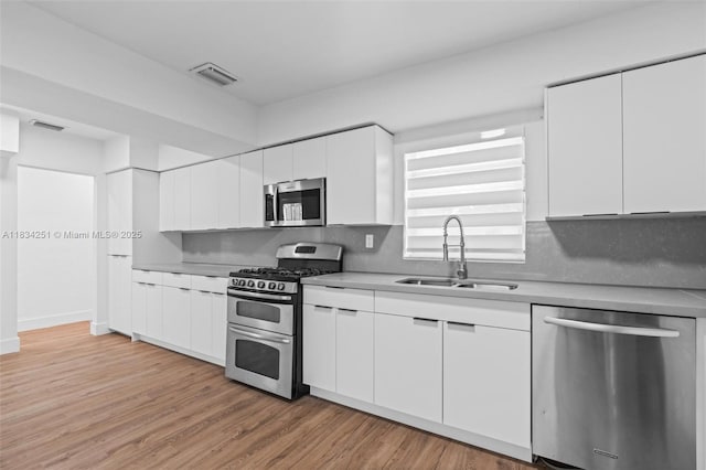 20620 Anchor Rd, Cutler Bay, FL 33189 - kitchen with stainless steel appliances, light countertops, white cabinets, and light wood-type flooring