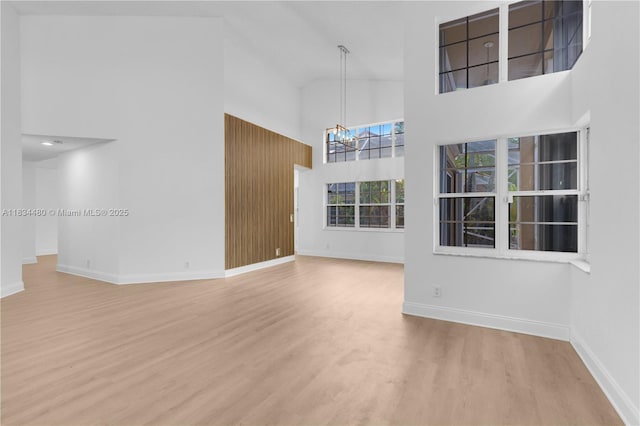 1525 Seabay Rd, Weston, FL 33326 - unfurnished living room with a high ceiling, a chandelier, and wood finished floors