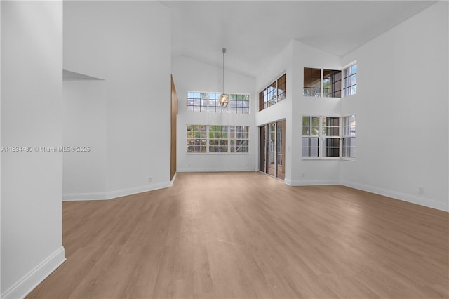 1525 Seabay Rd, Weston, FL 33326 - unfurnished living room featuring a chandelier, light wood finished floors, and high vaulted ceiling