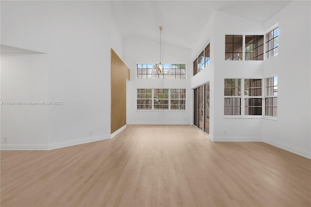 1525 Seabay Rd, Weston, FL 33326 - unfurnished living room featuring high vaulted ceiling, wood finished floors, and a chandelier
