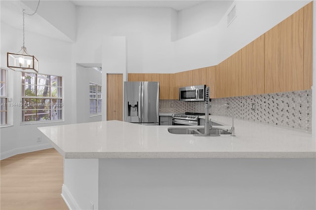 1525 Seabay Rd, Weston, FL 33326 - kitchen featuring appliances with stainless steel finishes, a peninsula, tasteful backsplash, modern cabinets, and a chandelier