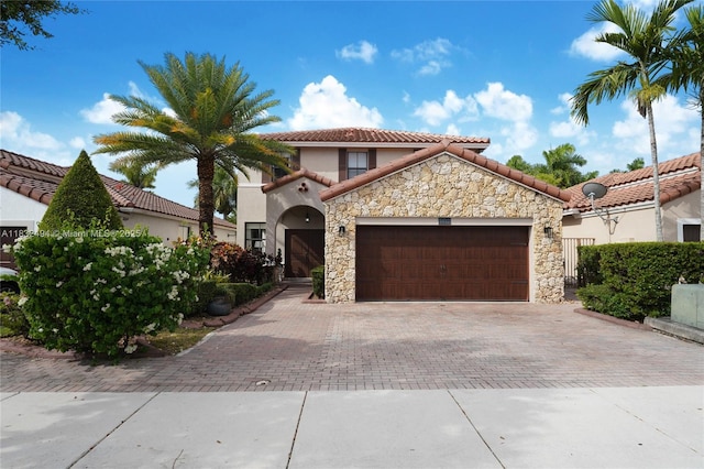 9932 NW 10th St, Miami, FL 33172 - mediterranean / spanish home with stone siding, decorative driveway, a garage, a tile roof, and stucco siding