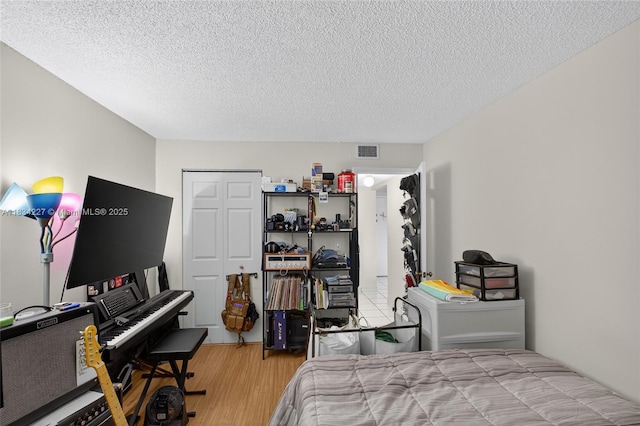 7745 SW 86th St Unit D-222, Miami, FL 33143 - bedroom featuring light wood-style flooring, a closet, and a textured ceiling