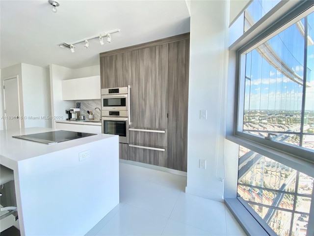 851 NE 1st Ave Unit 2802, Miami, FL 33132 - kitchen featuring modern cabinets, black electric cooktop, white cabinetry, light countertops, and light tile patterned floors