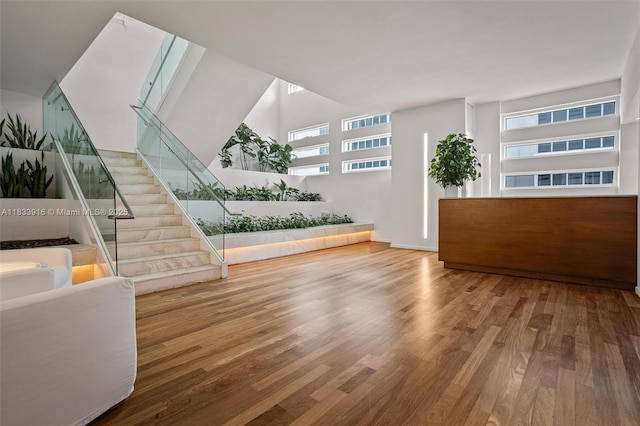 1040 Biscayne Blvd Unit 2108, Miami, FL 33132 - unfurnished living room featuring wood finished floors, stairway, and a towering ceiling