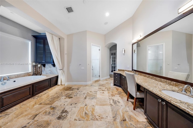 16701 SW 49th St, Southwest Ranches, FL 33331 - bathroom with two vanities, a bath, stone finish floors, and a shower