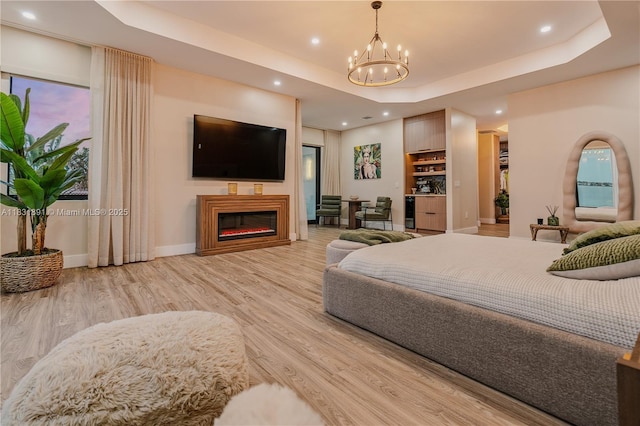 18269 SW 54th St, Miramar, FL 33029 - bedroom featuring a chandelier, a tray ceiling, wood finished floors, a glass covered fireplace, and recessed lighting