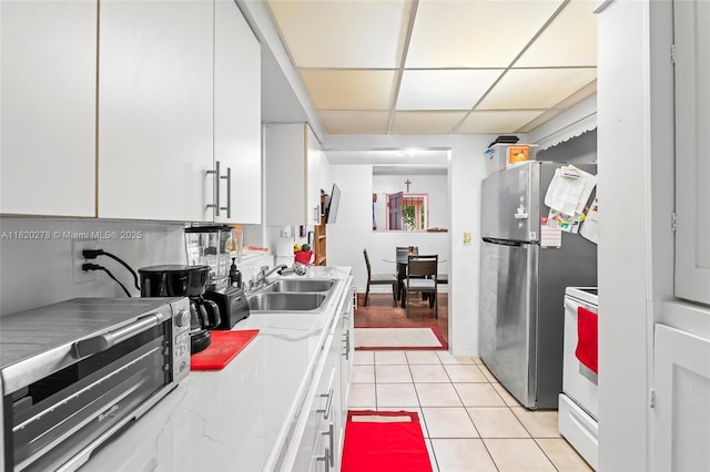 1430 NE 148th St, Miami, FL 33161 - kitchen with freestanding refrigerator, white cabinetry, light tile patterned floors, white electric range, and light countertops
