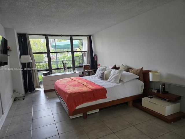 1000 Parkview Dr Unit 114, Hallandale Beach, FL 33009 - bedroom featuring a textured ceiling, a wall of windows, and light tile patterned floors