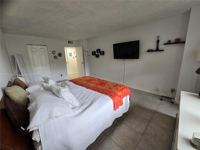 1000 Parkview Dr Unit 114, Hallandale Beach, FL 33009 - tiled bedroom featuring a textured ceiling and a closet