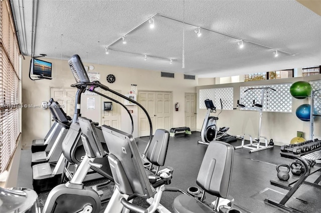 1000 Parkview Dr Unit 114, Hallandale Beach, FL 33009 - exercise room featuring rail lighting and a textured ceiling