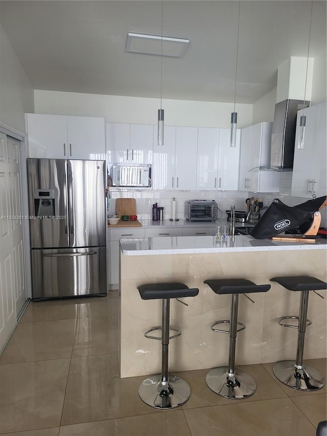 16909 SW 141st Ct, Miami, FL 33177 - kitchen featuring stainless steel appliances, a kitchen breakfast bar, white cabinetry, and backsplash