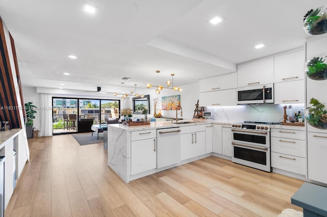 4000 NE 168th St Unit 113B, North Miami Beach, FL 33160 - kitchen with white appliances, a peninsula, open floor plan, white cabinets, and modern cabinets