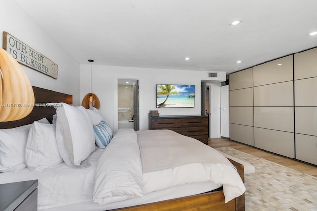 4000 NE 168th St Unit 113B, North Miami Beach, FL 33160 - bedroom with light wood-type flooring, recessed lighting, and connected bathroom