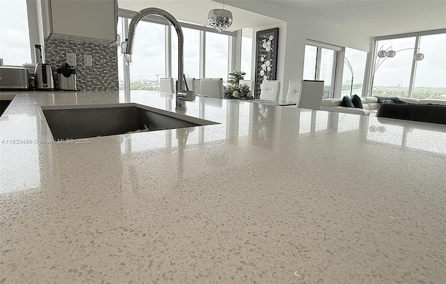 10275 Collins Ave Unit 722, Bal Harbour, FL 33154 - kitchen view of light stone counters, tasteful backsplash, and a chandelier