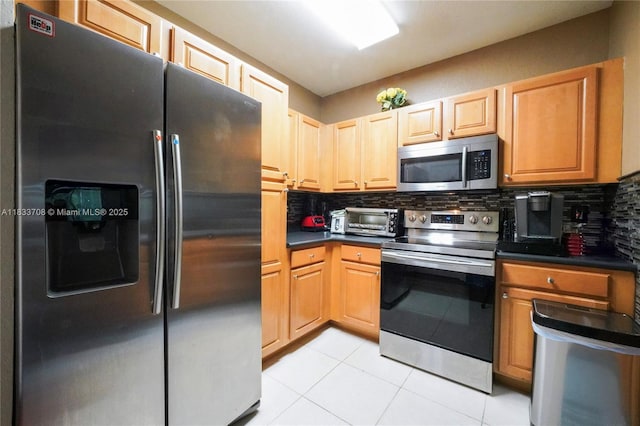3335 Palomino Dr, Davie, FL 33024 - kitchen with appliances with stainless steel finishes, dark countertops, backsplash, and light tile patterned floors