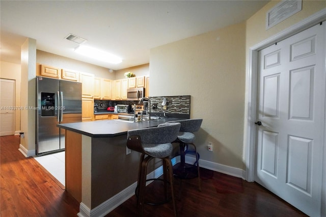 3335 Palomino Dr, Davie, FL 33024 - kitchen featuring appliances with stainless steel finishes, light wood-type flooring, a peninsula, a kitchen breakfast bar, and tasteful backsplash