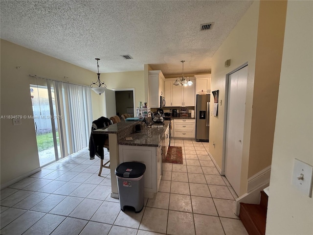 1851 SW 101st Way, Miramar, FL 33025 - kitchen featuring a chandelier, stainless steel appliances, a peninsula, a kitchen breakfast bar, and white cabinetry