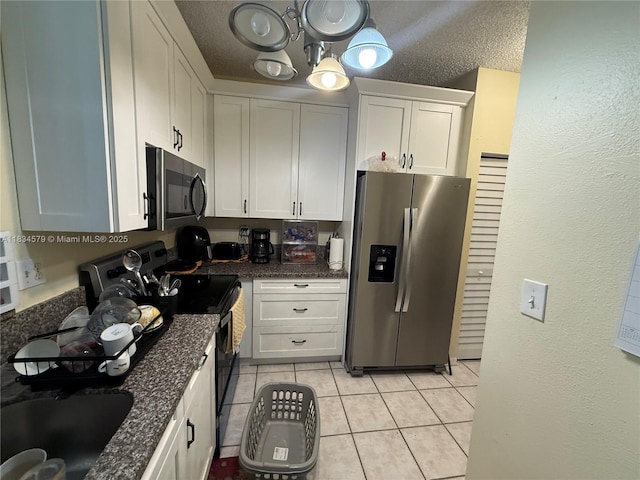 1851 SW 101st Way, Miramar, FL 33025 - kitchen featuring stainless steel appliances, light tile patterned flooring, a chandelier, white cabinetry, and dark stone counters