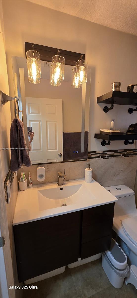 19185 SW 25th Ct, Miramar, FL 33029 - bathroom featuring vanity, a textured ceiling, tile walls, and tile patterned flooring