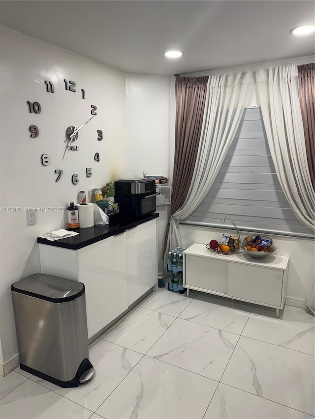 13355 SW 16th Ct Unit 105E, Pembroke Pines, FL 33027 - kitchen featuring light marble finish flooring, white cabinetry, dark countertops, and recessed lighting