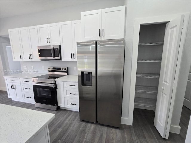 1605 W 11th St, Lehigh Acres, FL 33971 - kitchen featuring stainless steel appliances, dark wood finished floors, and white cabinetry