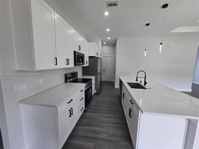 1605 W 11th St, Lehigh Acres, FL 33971 - kitchen with appliances with stainless steel finishes, recessed lighting, dark wood-style flooring, white cabinets, and light stone countertops