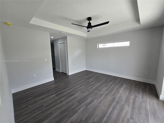 1605 W 11th St, Lehigh Acres, FL 33971 - unfurnished room with a tray ceiling, ceiling fan, and dark wood-style floors