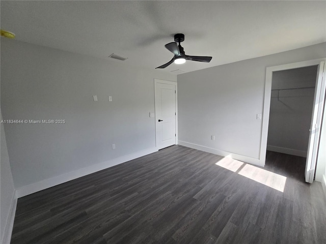 1605 W 11th St, Lehigh Acres, FL 33971 - unfurnished bedroom featuring dark wood finished floors, a closet, a ceiling fan, and a spacious closet