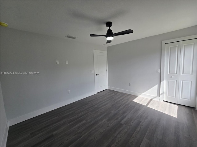 1605 W 11th St, Lehigh Acres, FL 33971 - unfurnished bedroom with dark wood-style flooring, a closet, and a ceiling fan