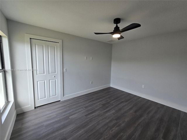 1605 W 11th St, Lehigh Acres, FL 33971 - unfurnished bedroom with dark wood-style flooring, a closet, and a ceiling fan