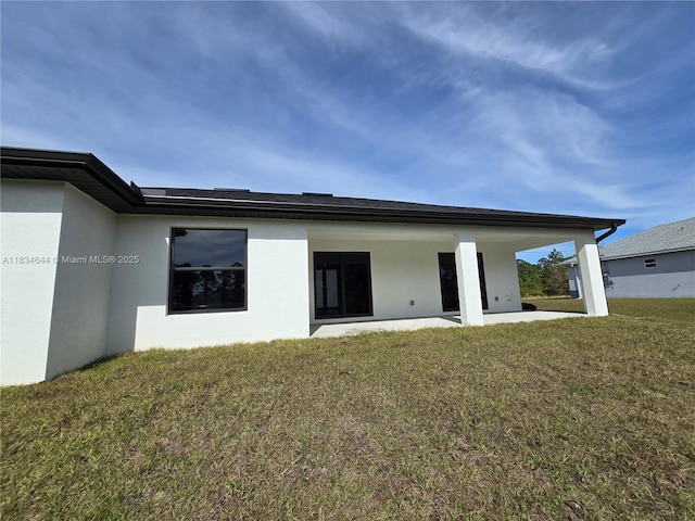 1605 W 11th St, Lehigh Acres, FL 33971 - rear view of house featuring stucco siding, a yard, and a patio