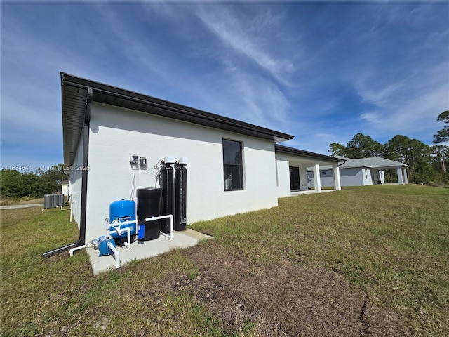 1605 W 11th St, Lehigh Acres, FL 33971 - rear view of house featuring a lawn and stucco siding