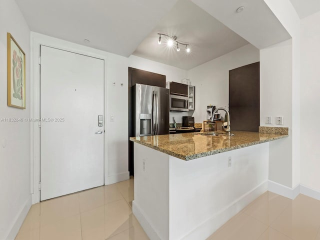950 Brickell Bay Dr Unit 1103, Miami, FL 33131 - kitchen featuring stainless steel appliances, a peninsula, light tile patterned flooring, and stone countertops