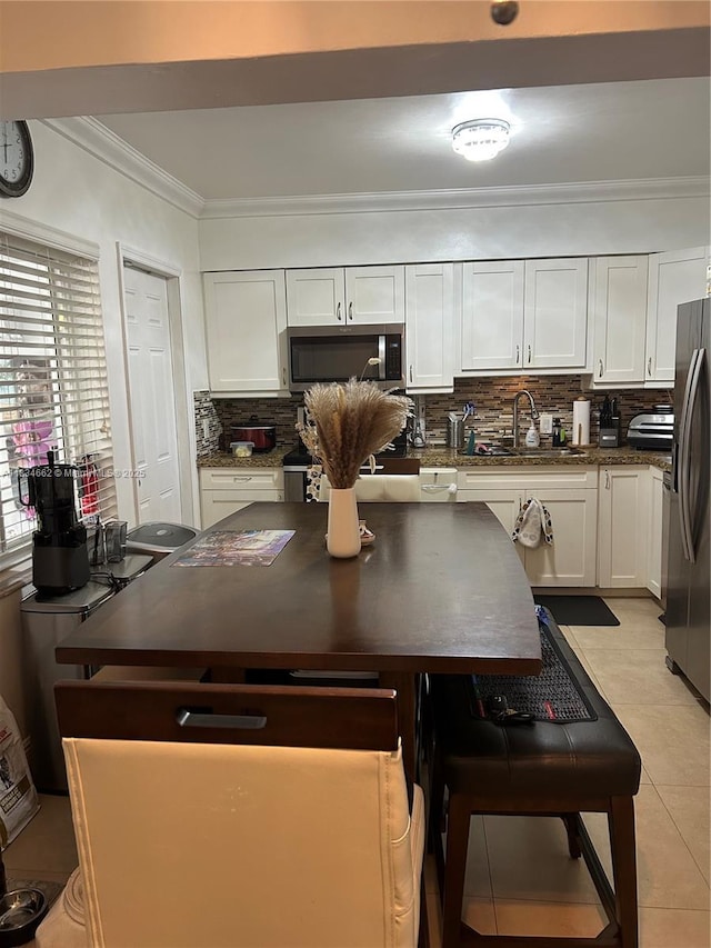 301 NW 146th St, Miami, FL 33168 - kitchen featuring appliances with stainless steel finishes, dark countertops, white cabinets, backsplash, and crown molding