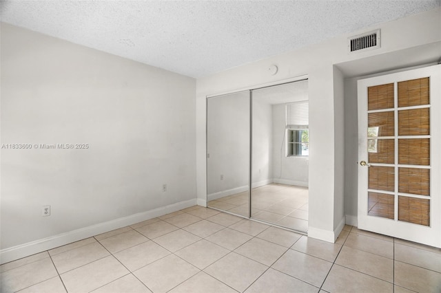 9310 Fontainebleau Blvd Unit 203, Miami, FL 33172 - unfurnished bedroom with a textured ceiling, a closet, and light tile patterned flooring