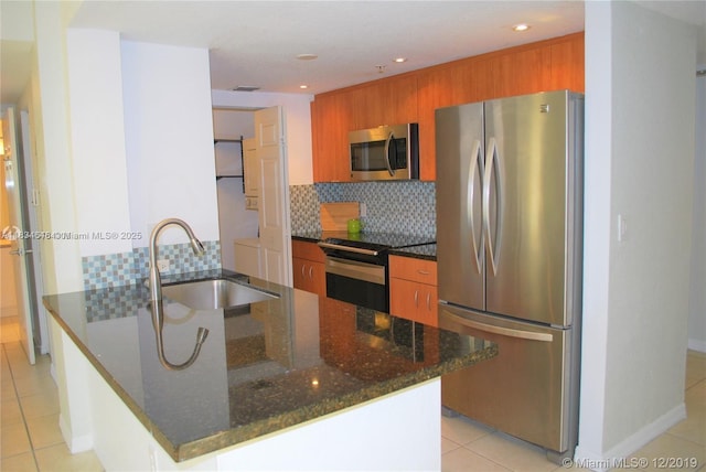 816 NW 11th St Unit 801, Miami, FL 33136 - kitchen featuring appliances with stainless steel finishes, brown cabinets, backsplash, light tile patterned floors, and recessed lighting