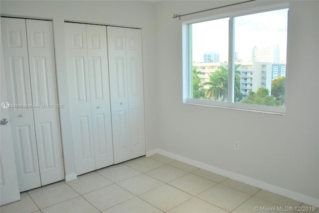 816 NW 11th St Unit 801, Miami, FL 33136 - unfurnished bedroom with baseboards and light tile patterned flooring