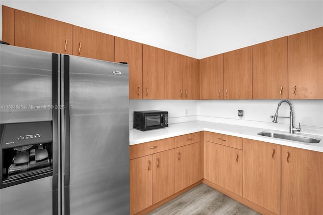 816 NW 11th St Unit 801, Miami, FL 33136 - kitchen featuring stainless steel refrigerator with ice dispenser, black microwave, light wood-style floors, and light countertops