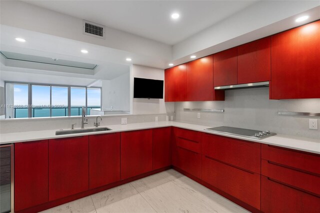 1331 Brickell Bay Dr Unit 2705, Miami, FL 33131 - kitchen featuring electric cooktop, red cabinetry, under cabinet range hood, recessed lighting, and light countertops